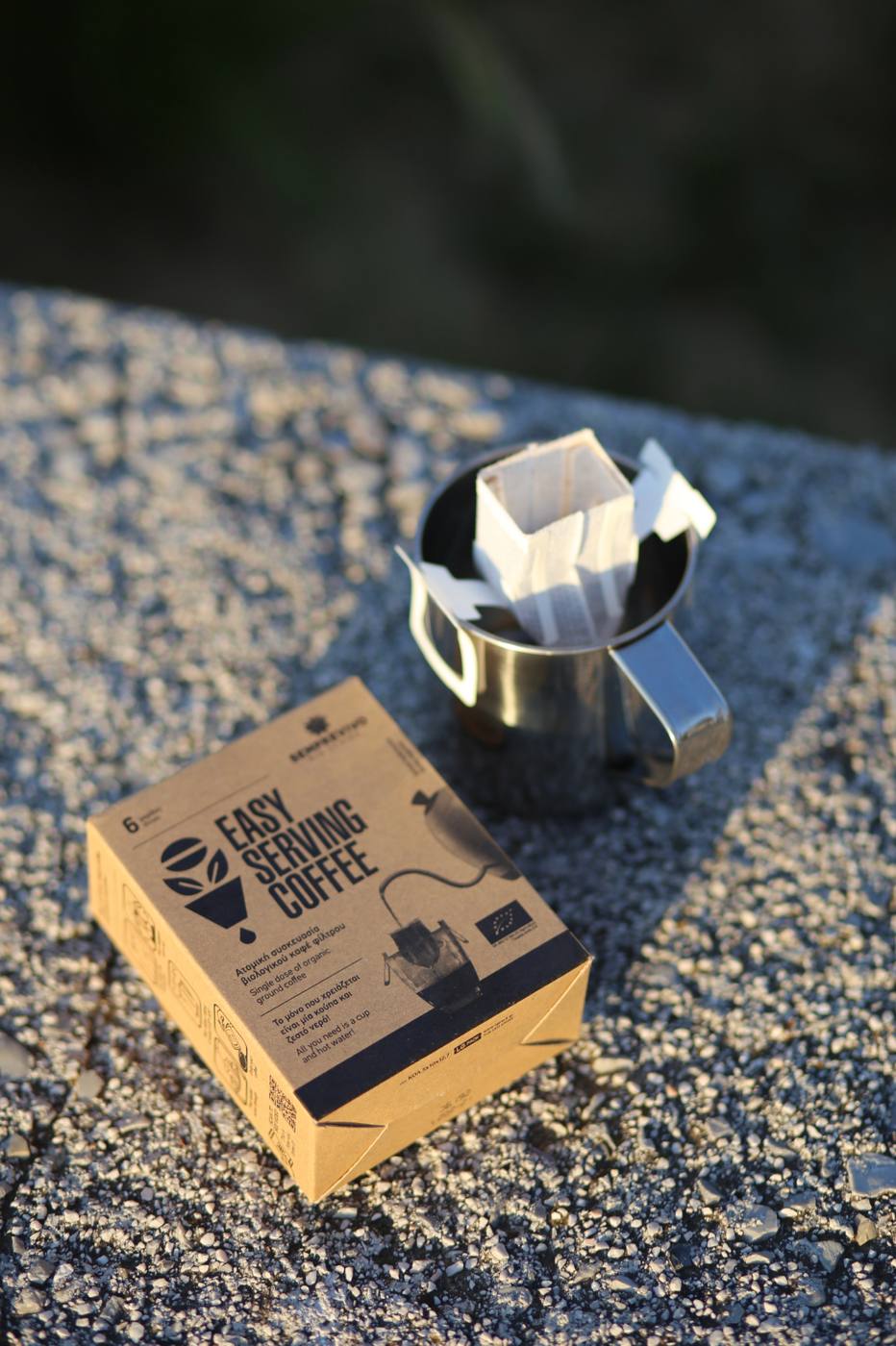 Semprevivo Easy Serving Coffee box beside a steel mug with a drip bag hanging on it